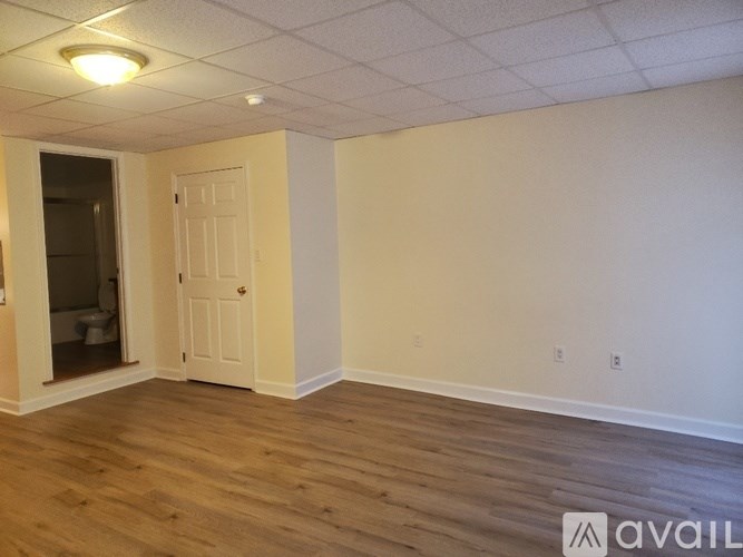 A room with wooden floors and a white door.