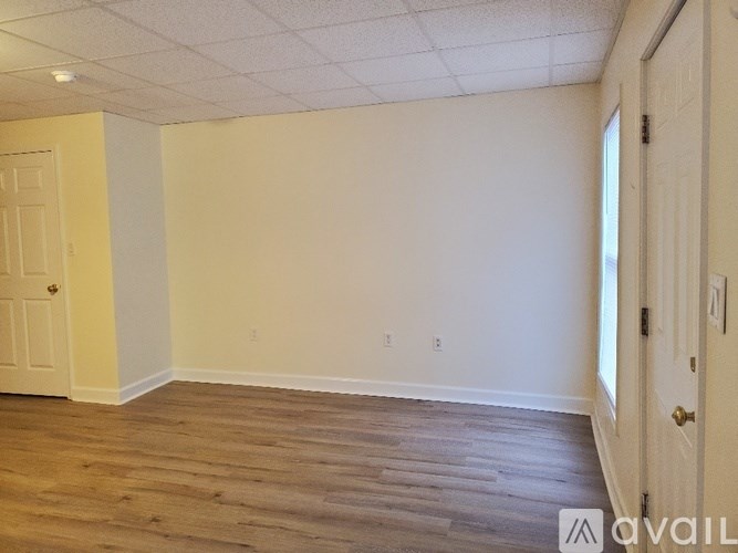 A room with wooden flooring and white walls.