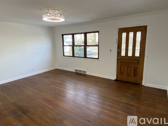 A room with wooden floors and a brown door.