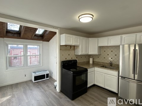A kitchen with a black oven and white cabinets.
