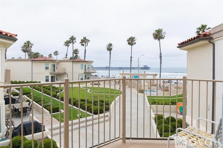A view from a balcony overlooking a pool and beach.