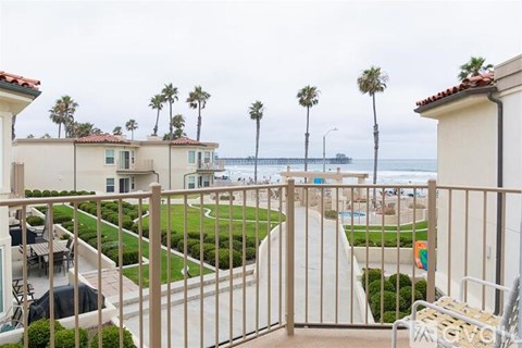 A view from a balcony overlooking a pool and beach.