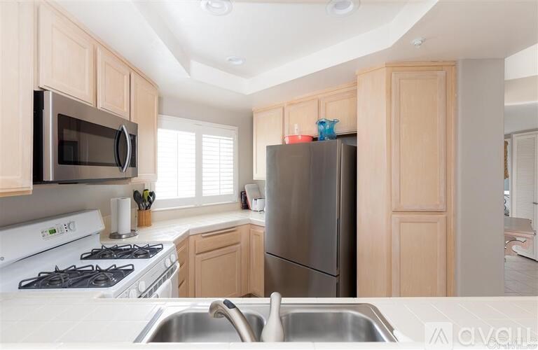 A kitchen with a stove, microwave, and refrigerator.