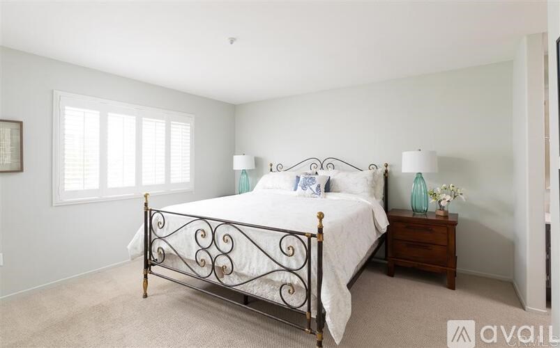 A bedroom with a large bed and a carpeted floor.