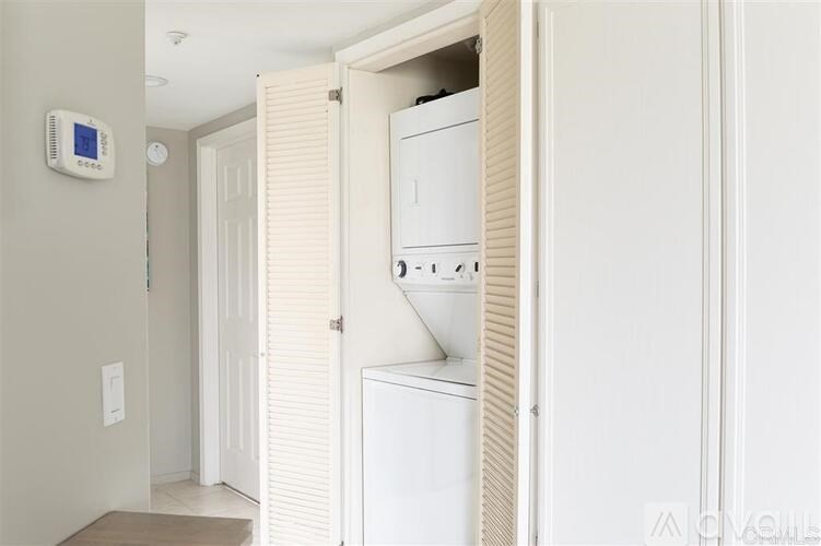 A white washing machine is in a small laundry room.