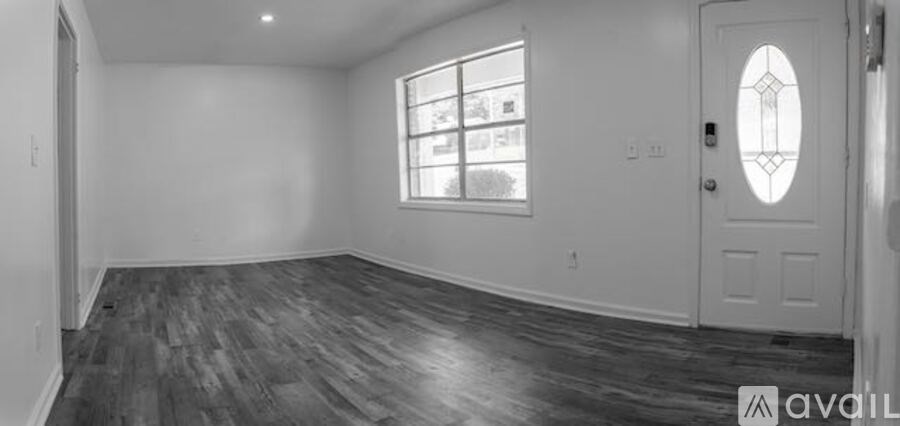 A room with a wooden floor and a white door.