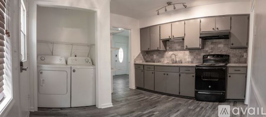 A kitchen with a black stove top oven and white appliances.