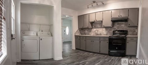 A kitchen with a black stove top oven and white appliances.