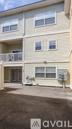 A two-story apartment building with a balcony on the second floor.