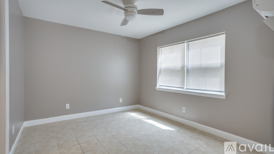 A room with a window and a fan on the ceiling.
