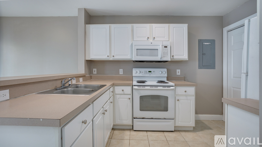 A kitchen with white cabinets and appliances.