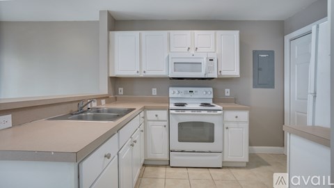 A kitchen with white cabinets and appliances.