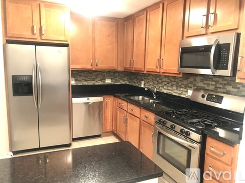 A kitchen with wooden cabinets and a black granite countertop.