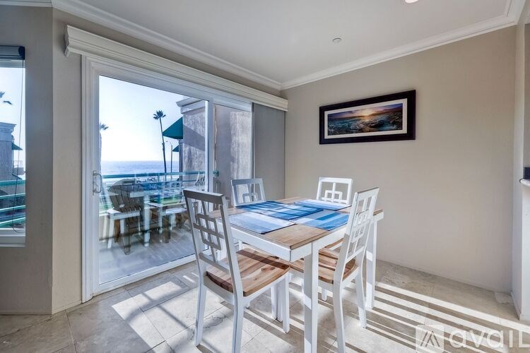 A dining room with a table and chairs and a view of the outside.
