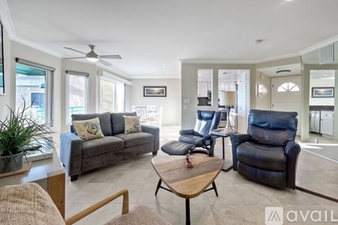 A living room with a grey couch, a brown coffee table, and a blue recliner.