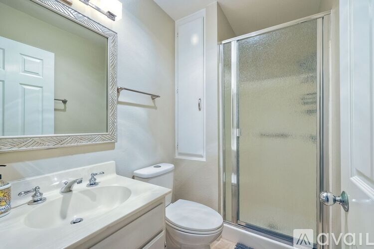 A bathroom with a sink, toilet, and shower.