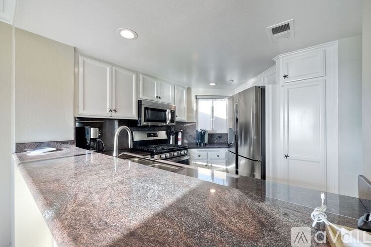 A kitchen with granite countertops and stainless steel appliances.