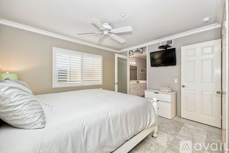 A bedroom with a bed, dresser, and television.