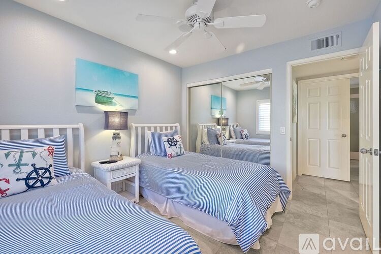 A bedroom with two beds and a ceiling fan.