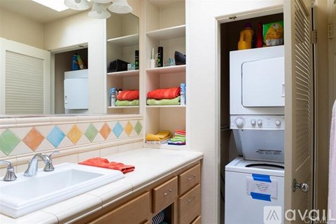 A kitchen with a white sink and a white refrigerator.