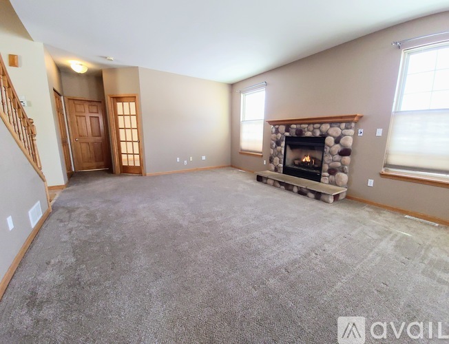 A living room with a fireplace and a carpeted floor.
