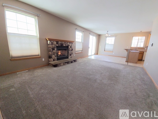 A living room with a fireplace and a carpeted floor.