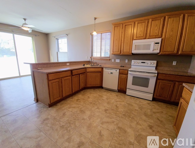 A kitchen with wooden cabinets and a white stove top oven.