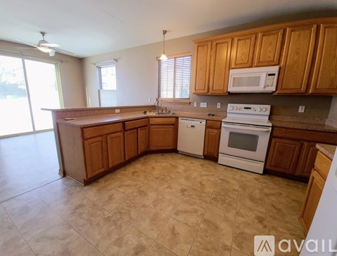 A kitchen with wooden cabinets and a white stove top oven.