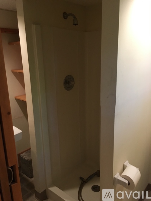 A white door with a toilet paper roll on the wall.