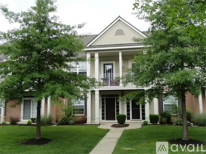 A house with a front porch and a tree in front of it.