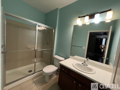 A bathroom with a toilet, sink, and shower.