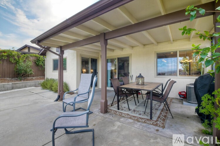 A patio with a table and chairs under a roof.
