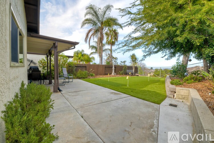 A house with a patio and a tree in the backyard.