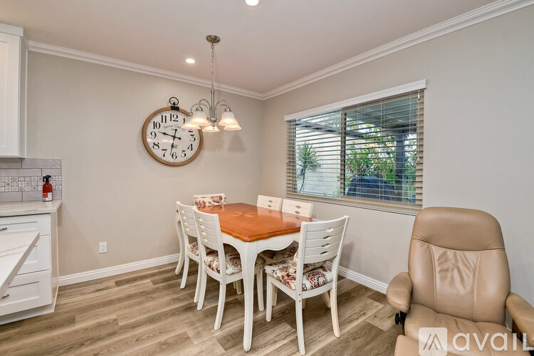 A dining room with a wooden table and chairs.