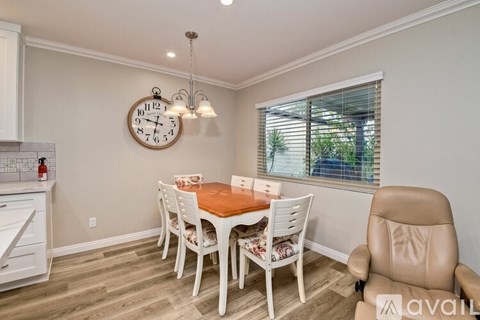 A dining room with a wooden table and chairs.