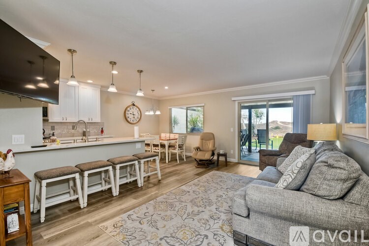 A living room with a grey couch and a bar area.
