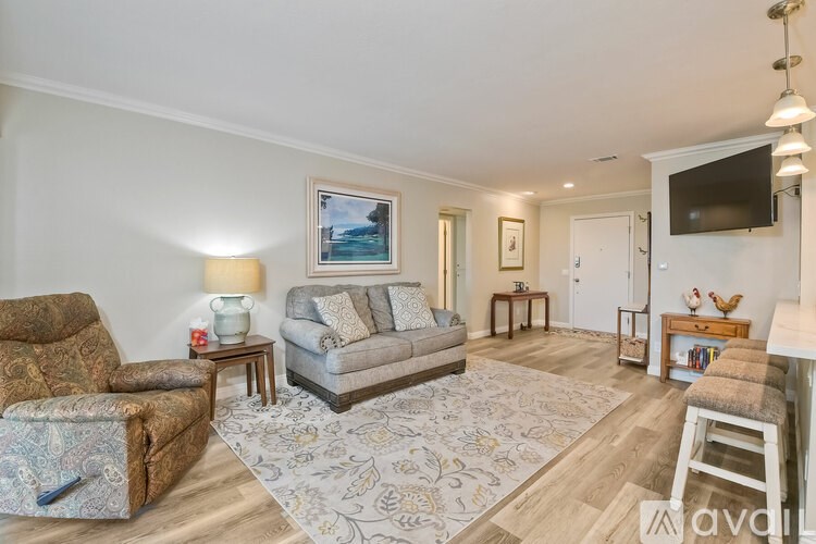 A living room with a couch, chair, and television.