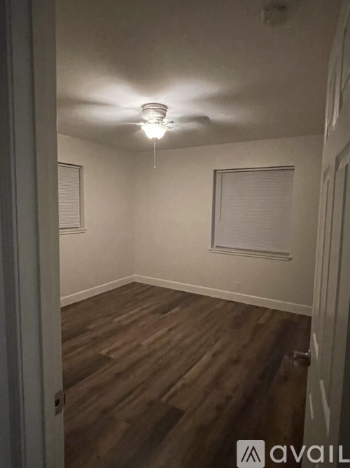A room with a light on and wooden floors.