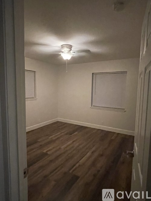 A room with a light on and wooden floors.