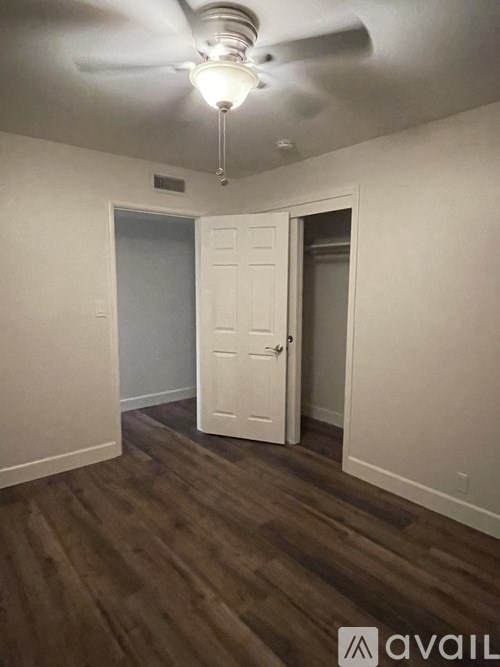 A room with a ceiling fan and a door.