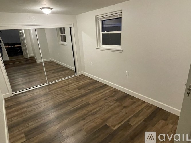 A room with a wooden floor and a window.