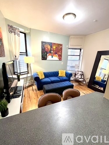 A living room with a blue couch and a grey countertop.