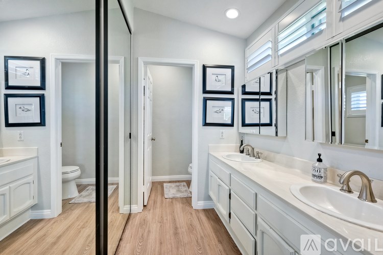A bathroom with a toilet, sink, and mirror.
