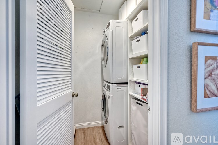 A small laundry room with a washer and dryer stacked on top of each other.