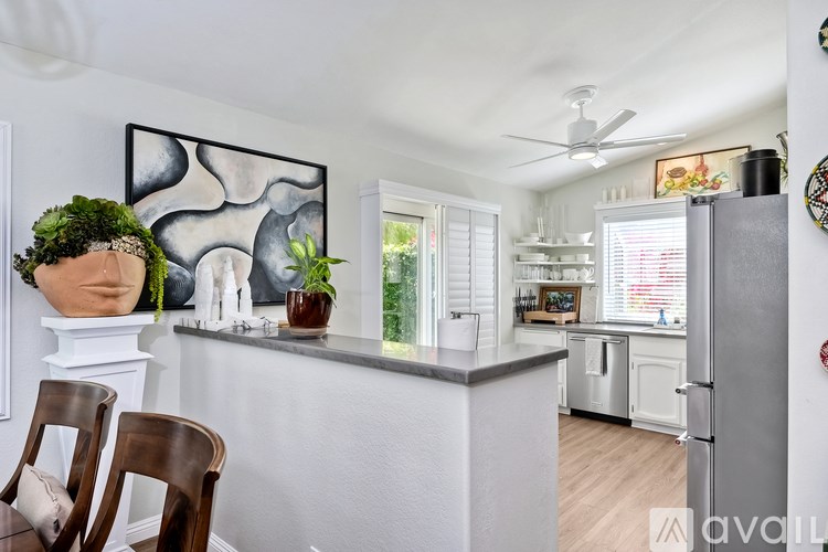 A kitchen with a white counter and a plant on it.