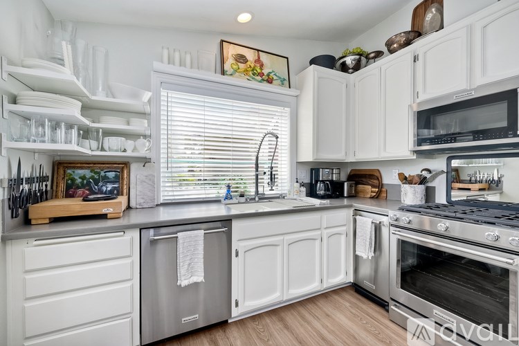 A kitchen with white cabinets and a stainless steel dishwasher.