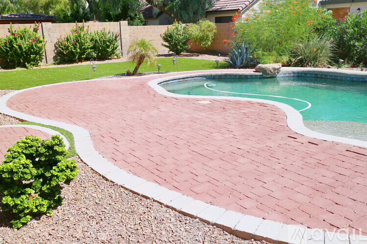 A red brick patio surrounds a small pool.