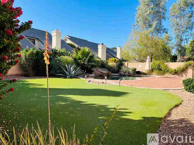 A garden with a lawn and a building in the background.