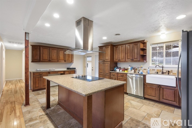 A kitchen with wooden cabinets and a granite countertop.