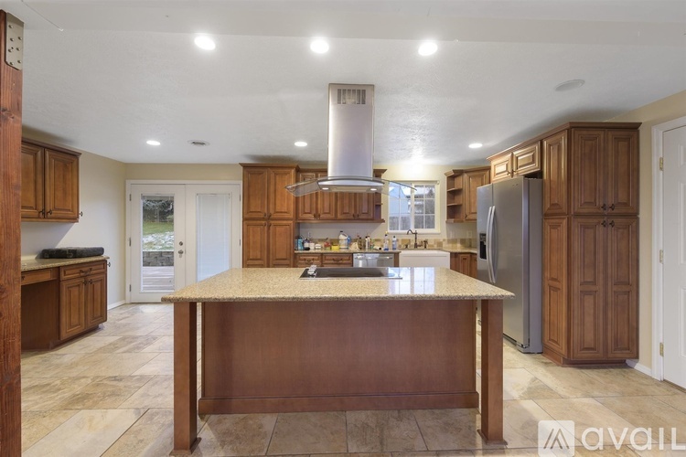 A kitchen with a granite countertop and wooden cabinets.